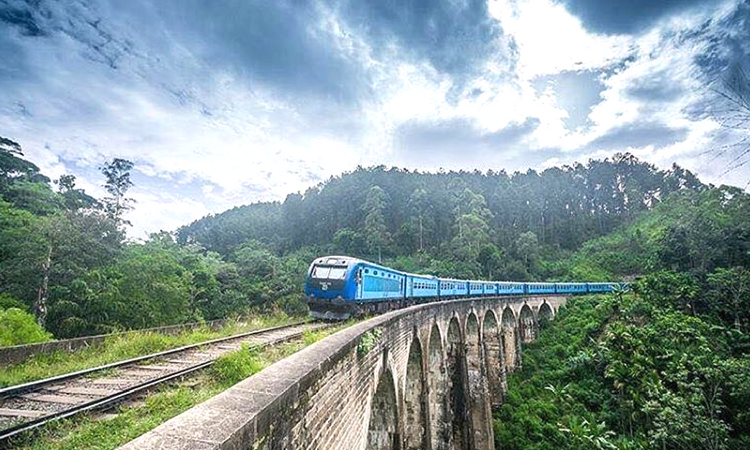 Blue train crossing the Nine Arch Bridge on the scenic Kandy to Ella route in Sri Lanka