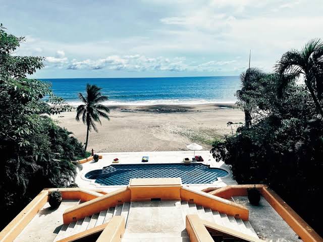 A beach villa opening onto white sand, with a private plunge pool among the palms