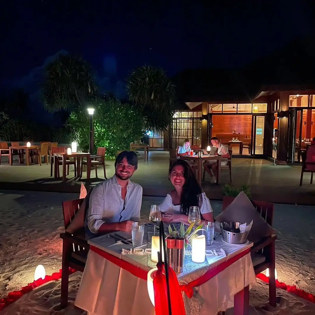 A couple relaxing on a quiet Maldives beach at sunset during their honeymoon